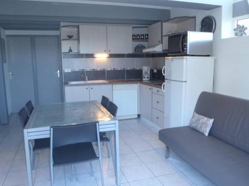 Il comprend une cuisine équipée d'une table, d'un canapé et d'un réfrigérateur. dans l'établissement VILLA 3 PCES MEZ 41m2 + TERRASSE 12m2 REF 4027, à Le Castellas