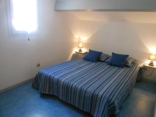 une chambre avec un lit avec deux oreillers bleus dans l'établissement VILLA 3 PCES MEZ 41m2 + TERRASSE 12m2 REF 4027, à Le Castellas