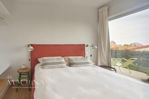 ein Schlafzimmer mit einem Bett und einem großen Fenster in der Unterkunft Las Flores del Mar, a un paso de Comillas in Comillas