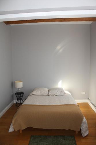 a bedroom with a bed with a white wall at Maison chaleureuse avec grande terrasse in Nîmes