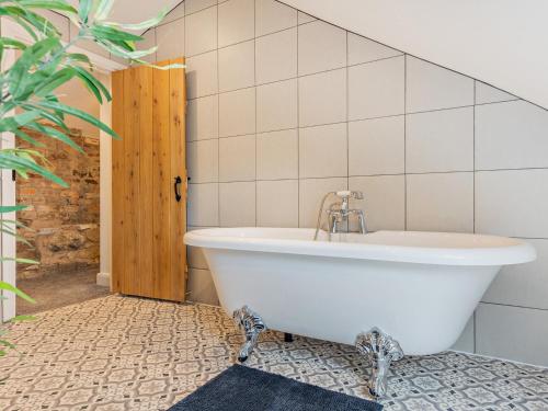 uma banheira branca na casa de banho com uma planta em 4 Bed in Mold 92663 em Treuddyn