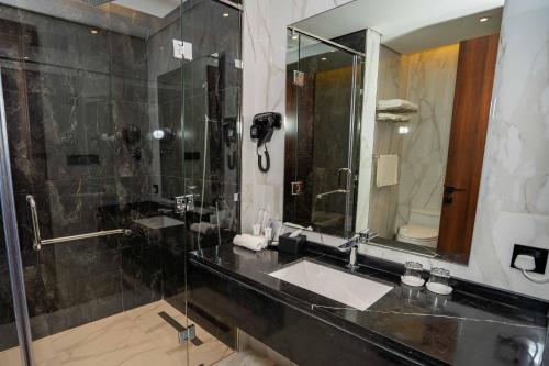 a bathroom with a sink and a shower at Le Bosquet in Shaqra