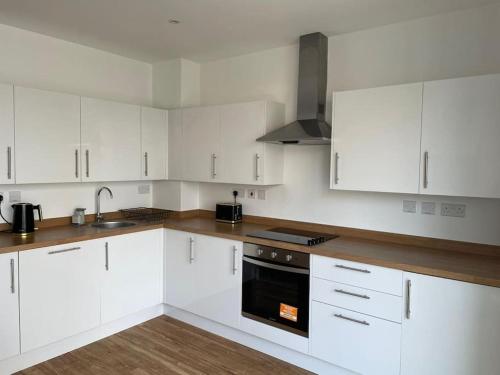a kitchen with white cabinets and a black oven at Home from Home in Brompton