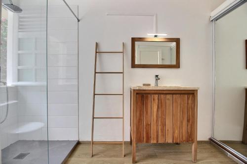 een badkamer met een ladder, een wastafel en een spiegel bij Villa Flamboyant in Le François