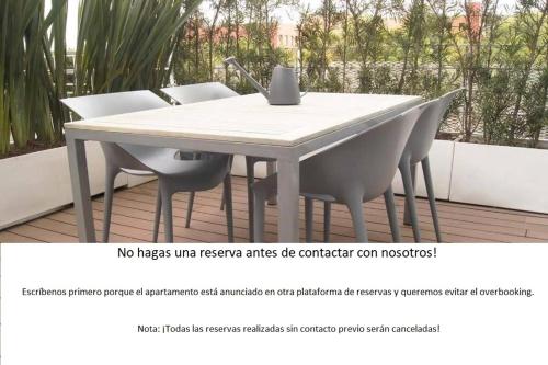 a white table and chairs with a laptop on it at Design Apartment with Amazing Private Terrace in Mexico City