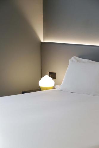 a bedroom with a large white bed and a lamp at Arryvo Hotel in Lecce