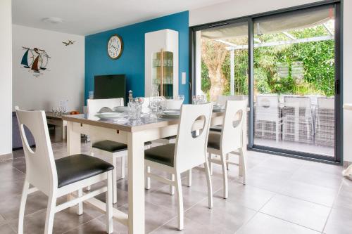 une salle à manger avec une table et des chaises dans l'établissement Maison pour 7 - jardin - accès pmr - 5min plage, à Fouesnant
