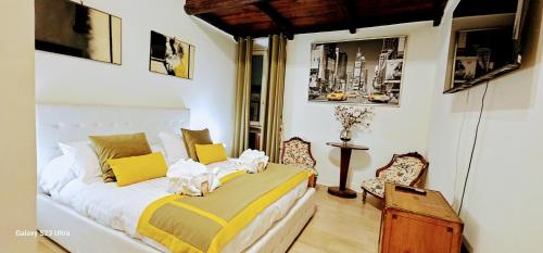 1 dormitorio con 1 cama con almohadas amarillas y blancas en Piazza di Spagna Heart Of Rome Best LocatioN, en Roma