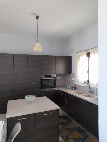 a kitchen with wooden cabinets and a white counter top at Manolo Saxophone Apartment Rethymno in Rethymno Town
