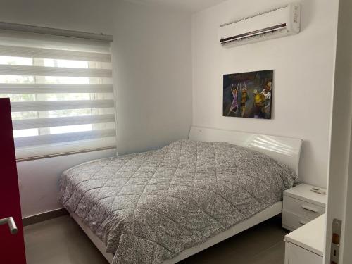a white bedroom with a bed and a window at Almaza Bay, 2 bd ground floor (Prime location) in Marsa Matruh
