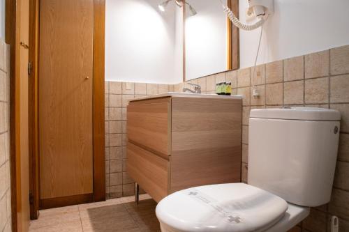 ein Badezimmer mit einem WC, einem Waschbecken und einem Spiegel in der Unterkunft Renovado apartamento a 10 min del Aeropuerto y a 3 min de IFEMA in Madrid