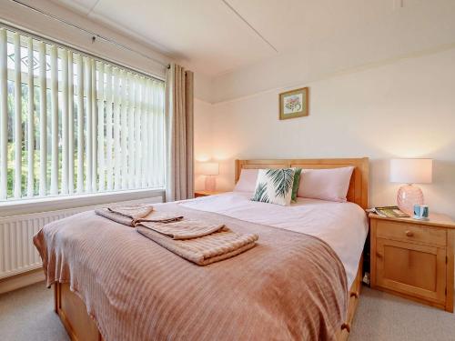 a bedroom with a large bed and a window at 4 Bed in Aberporth 93783 in Aberporth