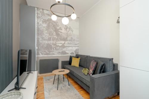 een woonkamer met een bank en een tv bij Stylish Grey Apartments with a City View in Poznań by Renters in Poznań