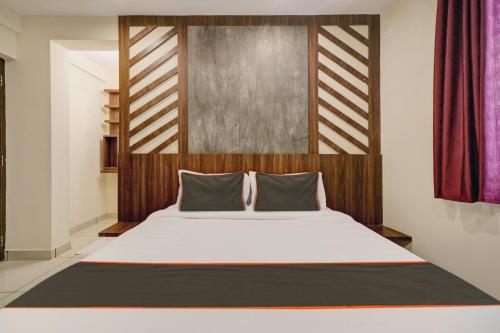 a bedroom with a large bed with a wooden headboard at GYPSY HOTEL CUSAT in Cochin