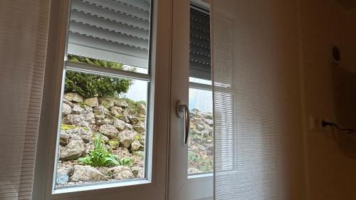 ein Fenster mit Blick auf eine Felswand in der Unterkunft Ferienwohnung Zehmerhof in Walpertskirchen