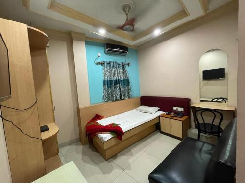 a small bedroom with a bed and a chair at Starline Hotel in Agartala