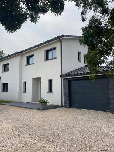 a white house with a garage at Grande villa avec piscine et spa in Longages