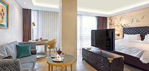 a hotel room with a large bed and a living room at Wanda Vista Istanbul in Istanbul