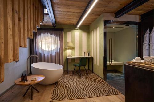 a bathroom with a tub and a table and a desk at Villa Balis Crema Verona Hills in Grezzana