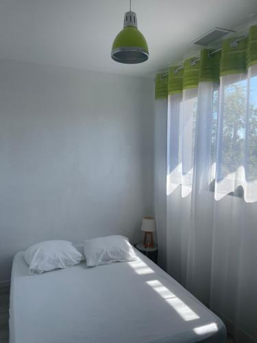 a white bedroom with a bed and a window at Grande villa avec piscine et spa in Longages