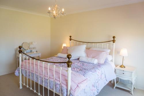 a bedroom with a bed with pink and white pillows at Doleen House in Ballyconneely