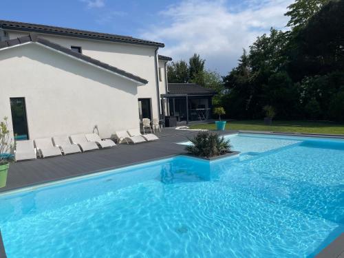 a large blue swimming pool next to a house at Grande villa avec piscine et spa in Longages