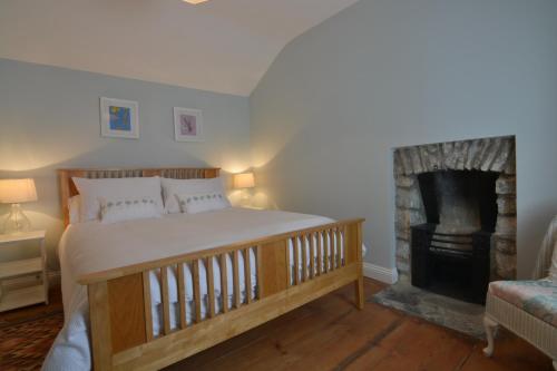 a bedroom with a large bed and a fireplace at Y Bwthyn Aberaeron in Aberaeron