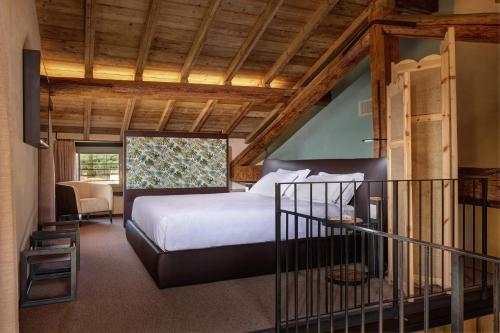 sypialnia z łóżkiem w pokoju z drewnianym sufitem w obiekcie Villa Balis Crema Verona Hills w mieście Grezzana