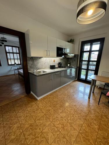 a kitchen with white cabinets and a wooden floor at Kutna Hora perfect apartment in Kutná Hora