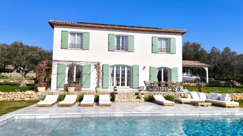 a villa with a swimming pool in front of a house at Lou Masadous : Magnifique villa tout confort avec piscine chauffée 11x3.5 in Montauroux