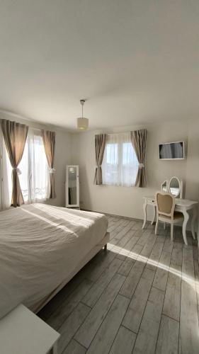 une chambre avec un grand lit et une table et des chaises dans l'établissement Lou Masadous : Magnifique villa tout confort avec piscine chauffée 11x3.5, à Montauroux