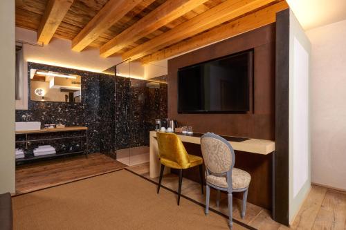 a hotel room with a television and two chairs at Villa Balis Crema Verona Hills in Grezzana