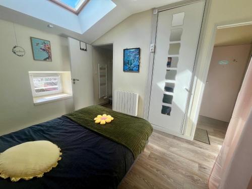 een slaapkamer met een bed met een gele bloem erop bij Le Repaire, accès terrasse de l'établissement in Rives