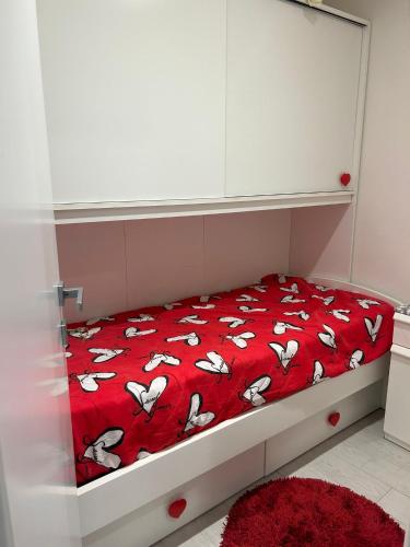 a bed with a red blanket with white cows on it at Casa vacanze da Mely in Marsala