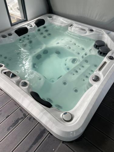 a jacuzzi tub sitting on a deck at Grande villa avec piscine et spa in Longages
