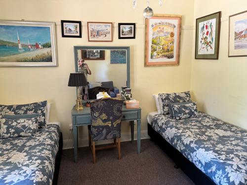 a room with two beds and a desk with a mirror at River Front Estate in Huonville