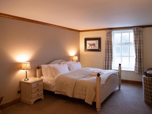 a bedroom with a bed with white sheets and a window at The Vestry in Chichester