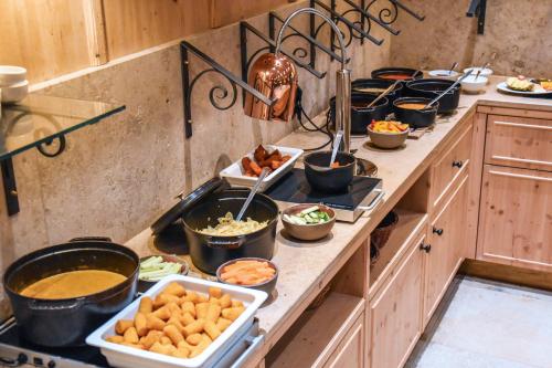 a kitchen with many dishes of food on a counter at Spa & Resort Bachmair Weissach, LUXURY FAMILY RESORT in Rottach-Egern
