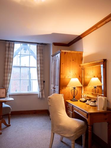 a room with a desk and a chair and a window at The Vestry in Chichester