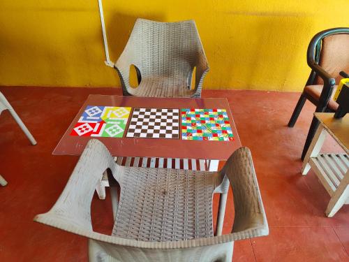 a table and chairs with a chess board on it at Rain Raga Resort in Mahabaleshwar