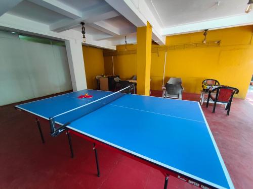 a blue ping pong table in a room with chairs at Rain Raga Resort in Mahabaleshwar