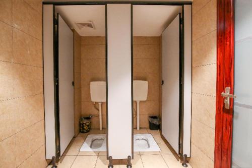 - deux miroirs dans une salle de bains avec deux toilettes dans l'établissement City Comfort Inn Jingzhou Museum Ancient City Xinnanmen, à Jingzhou