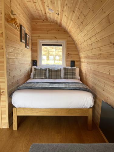 a bed in a small room in a log cabin at Stoer Pods - Quinag Pod in Lochinver