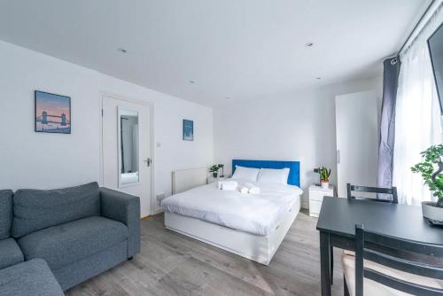 a bedroom with a bed and a couch and a table at Pass the Keys Kings Cross City Escape in London