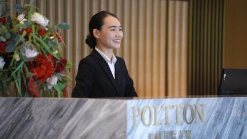 una mujer de pie detrás de una mesa con un podio en Poltton International Service Apartment Chaozhou Ancient Town Linjiang en Chaozhou