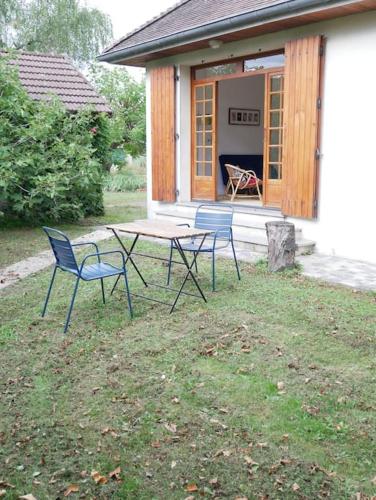 3 chaises et une table devant une maison dans l'établissement Maison au calme avec jardin à 5 min de Tournus, à Cuisery