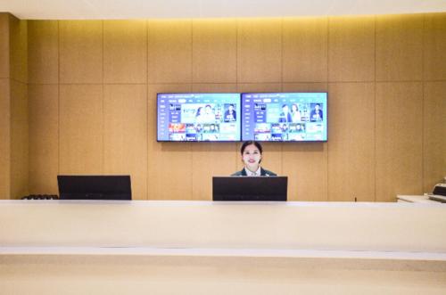 a woman sitting at a desk with a laptop at City Comfort Inn Yichang Sanxia Airport in Ku-lao-pei