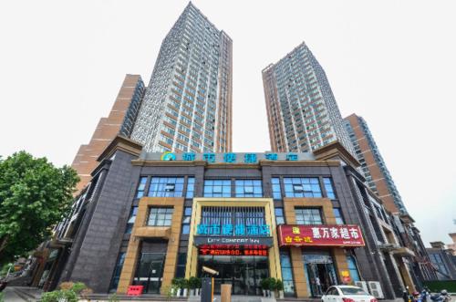 budynek z dwoma wysokimi wieżowcami w obiekcie City Comfort Inn Yichang Sanxia Airport w mieście Ku-lao-pei