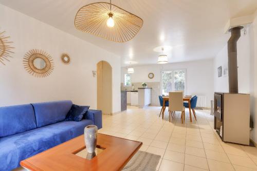 un salon avec un canapé bleu et une table dans l'établissement Séjour entre forêt et plage - Maison pour 7, à Saint-Hilaire-de-Talmont