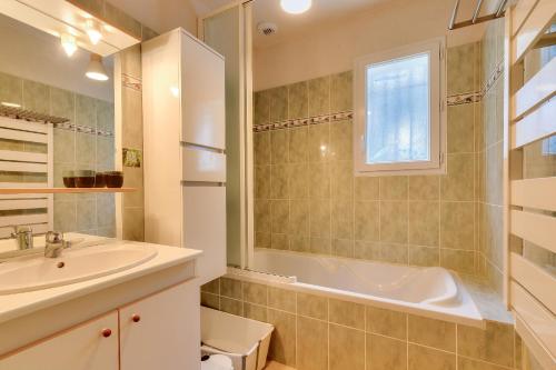 une salle de bain avec un lavabo, une baignoire et des toilettes dans l'établissement Séjour entre forêt et plage - Maison pour 7, à Saint-Hilaire-de-Talmont